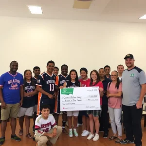 Community celebration with sports team and donation presentation.