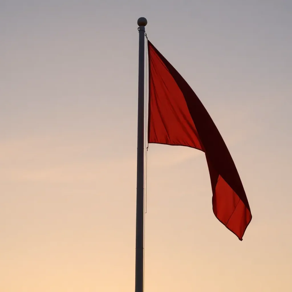 Flag at half-staff against a serene sunset backdrop.