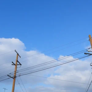 Power lines restored after storm with clear skies above.